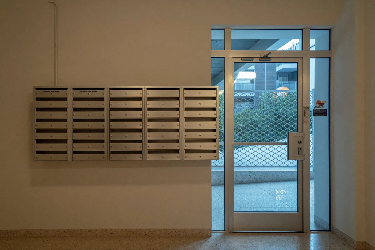 Portal de una comunidad de vecinos en Valladolid con buzones y puerta de acceso con cerradura nueva
